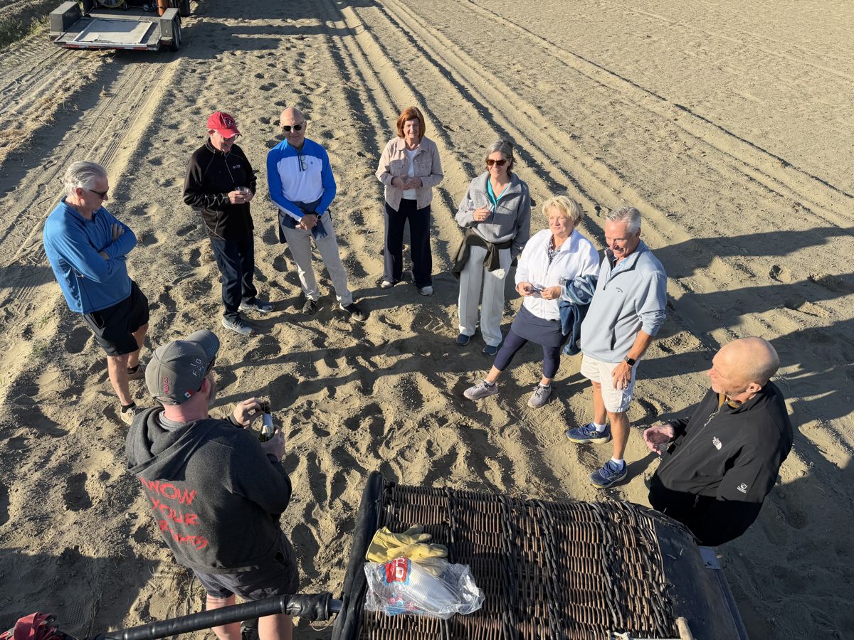 Passengers gathered in a circle on the sand for the post-flight toast