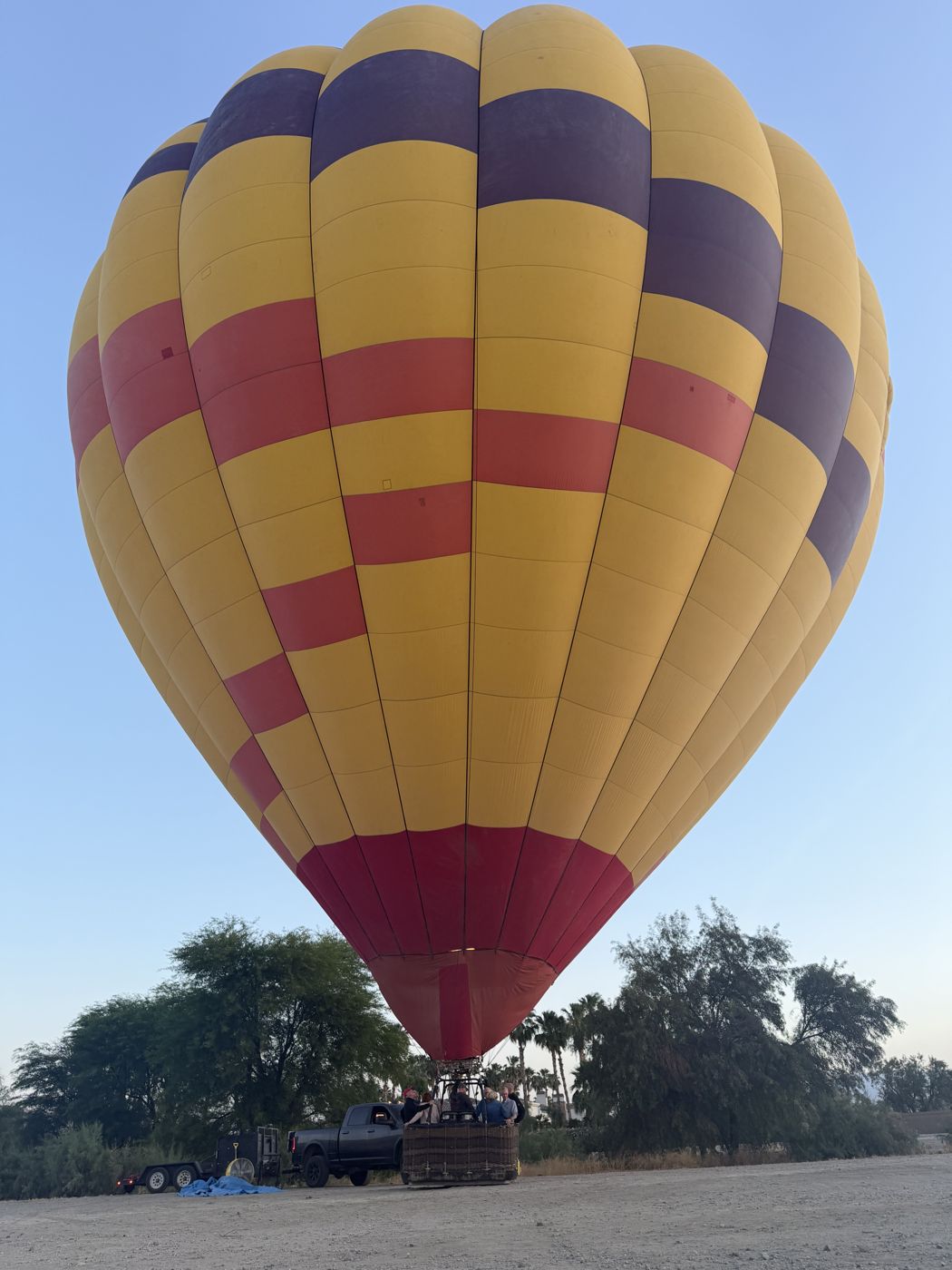 A fully inflated yellow and red checkered balloon standing upright at the launch site